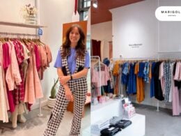 A woman stands smiling beside colorful clothing racks in a boutique. The store features neatly hung dresses and tops in pink, blue, and patterned fabrics. A sign on the wall reads “MARIGOLD MONTREAL.”.