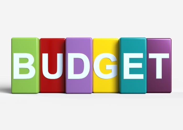 The word BUDGET is spelled out in large white letters on six colorful rectangular blocks: green, red, purple, yellow, teal, and violet, against a light background.
