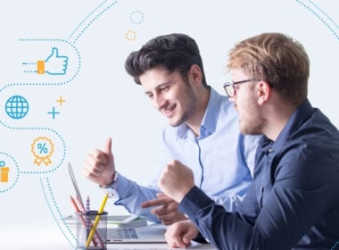 Two men sitting at a desk, smiling and giving thumbs up while looking at a laptop, with business and social media icons overlaid on the left side of the image.